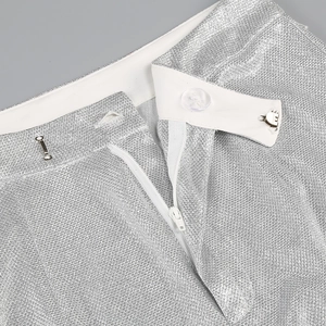 Detail of silver metallic fabric with zipper closure and transparent button on waistband