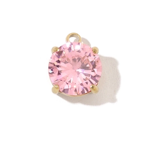 Close-up of golden stainless steel pendant with round faceted pink gemstone inlay