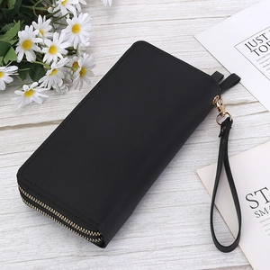 Detail of black double-zip long wallet featuring lychee pattern leather and wrist strap
