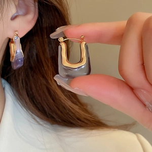 Macro detail of French vintage lilac acrylic U-shaped hoop earrings with gold trim