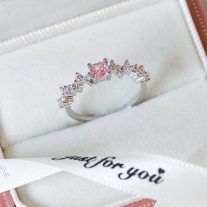 Macro shot of pink zircon heart ring in a white velvet box with a ribbon detail
