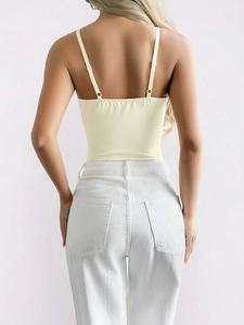 Detailed back view of a beige camisole featuring adjustable thin straps and slim fit design