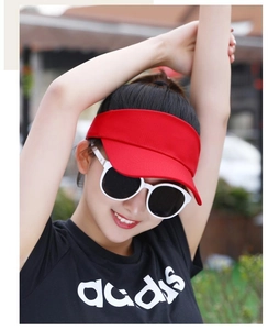 Close-up of a vibrant red sun visor cap with embroidered detail on female model