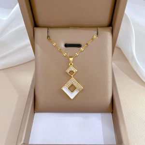 Macro shot of titanium steel necklace with white enamel square pendant in jewelry box