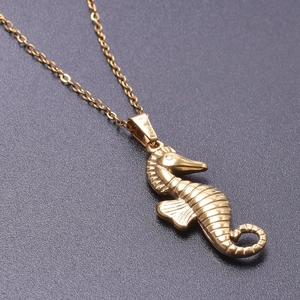 Macro shot of 18k gold plated stainless steel seahorse pendant on a fine O-chain necklace
