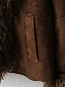 Detail view of brown suede jacket showing fuzzy faux fur trim and precision stitching