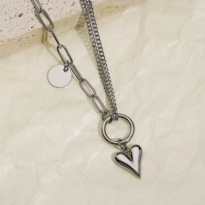 Detail of silver double-layered paperclip and fine chain with heart pendant