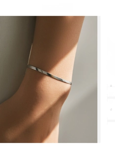 Gros plan détaillé d'un bracelet gourmette plat en argent s925 sur le poignet