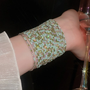Detail of mint green and iridescent rhinestone stretch bracelet in elegant party setting