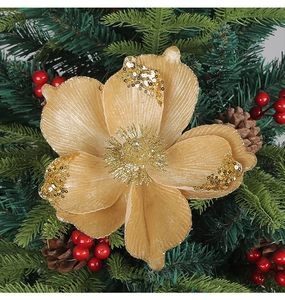 Macro view of gold glitter Christmas flower with sequins on green pine needles and cones