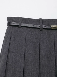 Detail view of dark grey pleated skirt with black waist belt and golden metal buckle