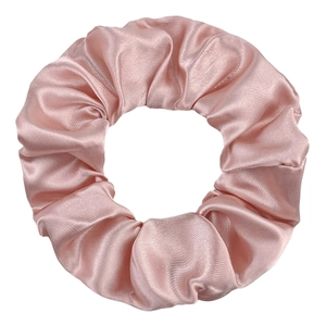 Detail of pink satin scrunchie showing smooth silk texture and elastic pleated design