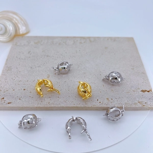 Detailed view of gold and silver copper plated cubic zirconia clasps on a stone surface