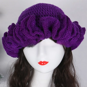 Detailed view of handmade purple crochet hat with stylish ruffled petal-like design edges