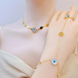 Detail of gold evil eye jewelry set with blue accents and sparkling white rhinestones