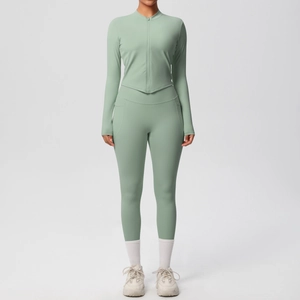 Détail d'ensemble yoga vert sauge montrant les poches latérales du legging et le zip frontal