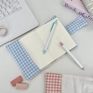 Detail of blue plaid fabric book cover with pink snap button and matching stationery set