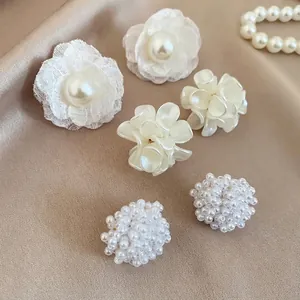 Vista dettagliata del set di 3 paia di orecchini con fiori di pizzo e eleganti perle