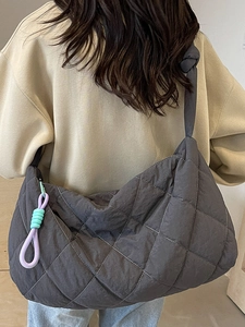 Quilted charcoal gray tote bag with knot strap and colorful accent charm detail