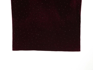 Macro shot of burgundy velvet fabric with sparkling rhinestones and plush fur trim detail