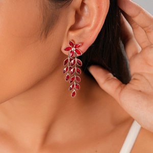 Close-up of vintage flower tassel earrings featuring red marquise cut glass gems