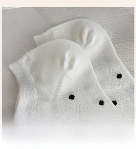 Detail view of white polka dot low cut boat socks featuring reinforced heel and mesh knit