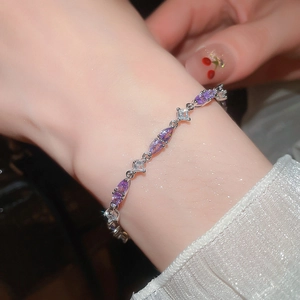 Detail of silver bracelet with purple marquise cut stones on a model wrist