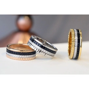 Detailed view of three tiered rings in gold, silver and rose gold with gemstone layers