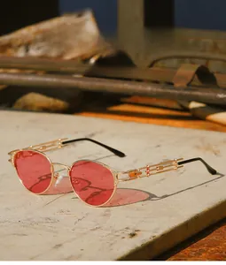 Detailed view of steampunk sunglasses with gold metal hollow temples and red lenses
