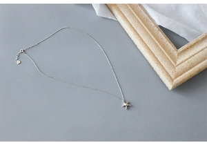 Detail of S925 sterling silver starfish pendant necklace on a minimalist gray background