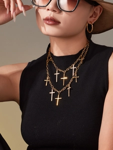 Détail d'un collier doré multi-rangs à croix serti de zircons sur un mannequin