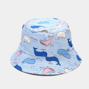 Detail of light blue bucket hat featuring cartoon whale patterns and swimming time text