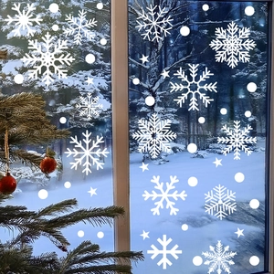 Detailed view of white snowflake static window decals on glass with snowy forest backdrop