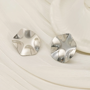 Minimalist silver stainless steel stud earrings with irregular wave disc texture