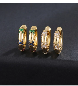 Macro shot of gold huggie earrings with colorful gemstones and micro-paved white zircons