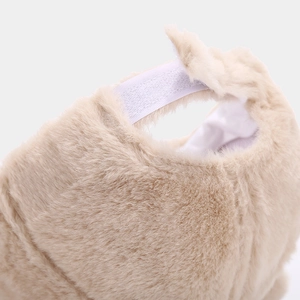 Detail of soft beige faux fur baseball cap featuring adjustable white velcro strap