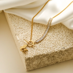Double layered gold necklace with butterfly pendant and rectangular zircon stones