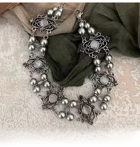 Detail of vintage gray pearl necklace with silver hollow flower and blue gemstone