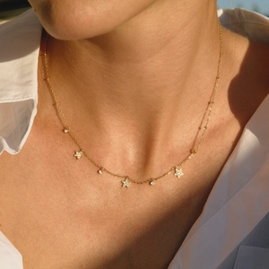 Collier en titane doré avec pendentifs étoiles en zircon sous une lumière naturelle