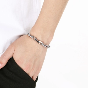 Men's minimalist silver stainless steel O-chain bracelet worn by a model on white background