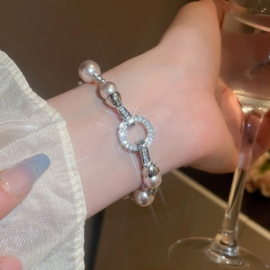 Bracelet élégant en perles et zircons brillants porté par un mannequin dans un cadre luxueux