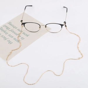 Detail of golden geometric metal chain for glasses and masks on a white background