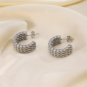 French vintage silver C-shaped twisted earrings in stainless steel on silk background