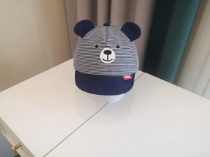 Detail of baby bear baseball cap with navy stripes and cute 3D ears on a white background