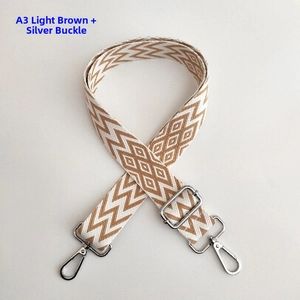 Detail of light brown and white wavy pattern shoulder strap with silver buckle hardware