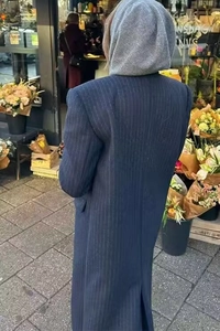 Rückansicht eines dunkelblau gestreiften Wollmantels mit grauer Strickkapuze im Freien