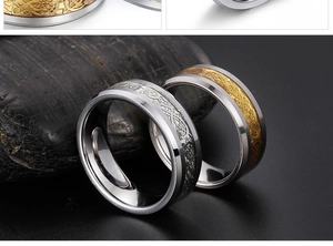 Detail shot of tungsten rings with Celtic knot engraving resting on dark natural stones