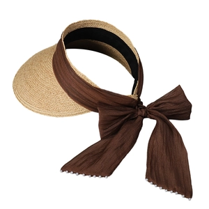 Straw sun visor hat for women with foldable design and pearl bow detailing on white background