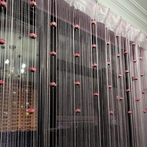 Detail of pink rose fringe curtain featuring dense silver silk threads and floral accents