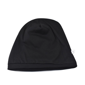 Detailed view of a soft black thin knit beanie hat showing texture and side tag.